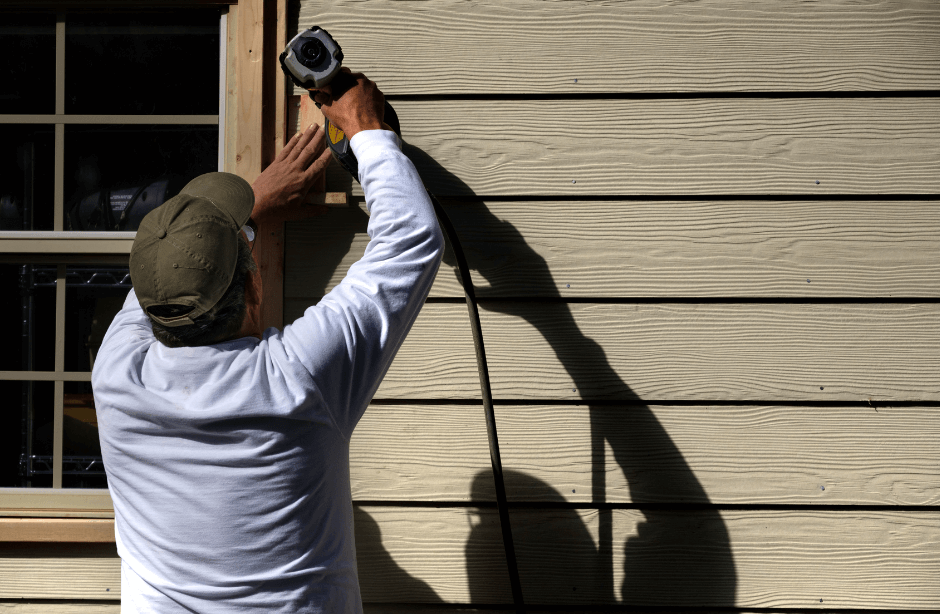 man fixing the siding